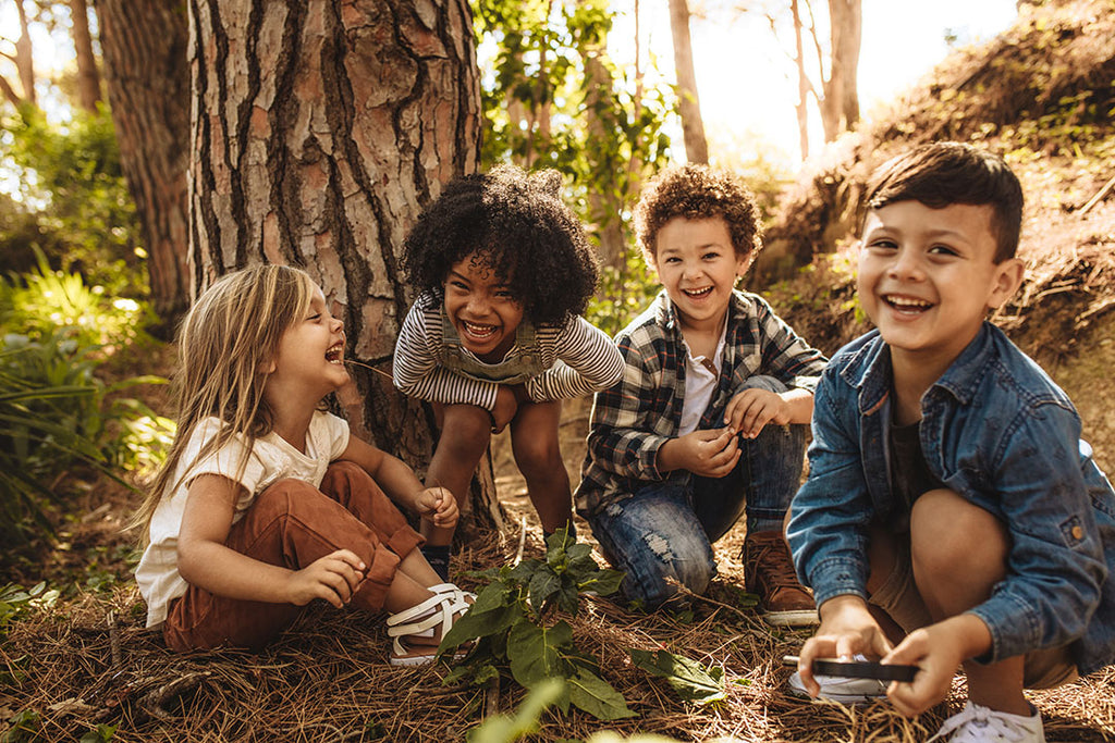 Vier Kinder spielen im Wald